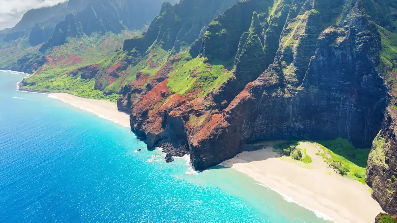 Fakta om Hawaii: Dramatiska gröna berg möter turkost hav och vita stränder längs Na Pali Coast på Kauai.