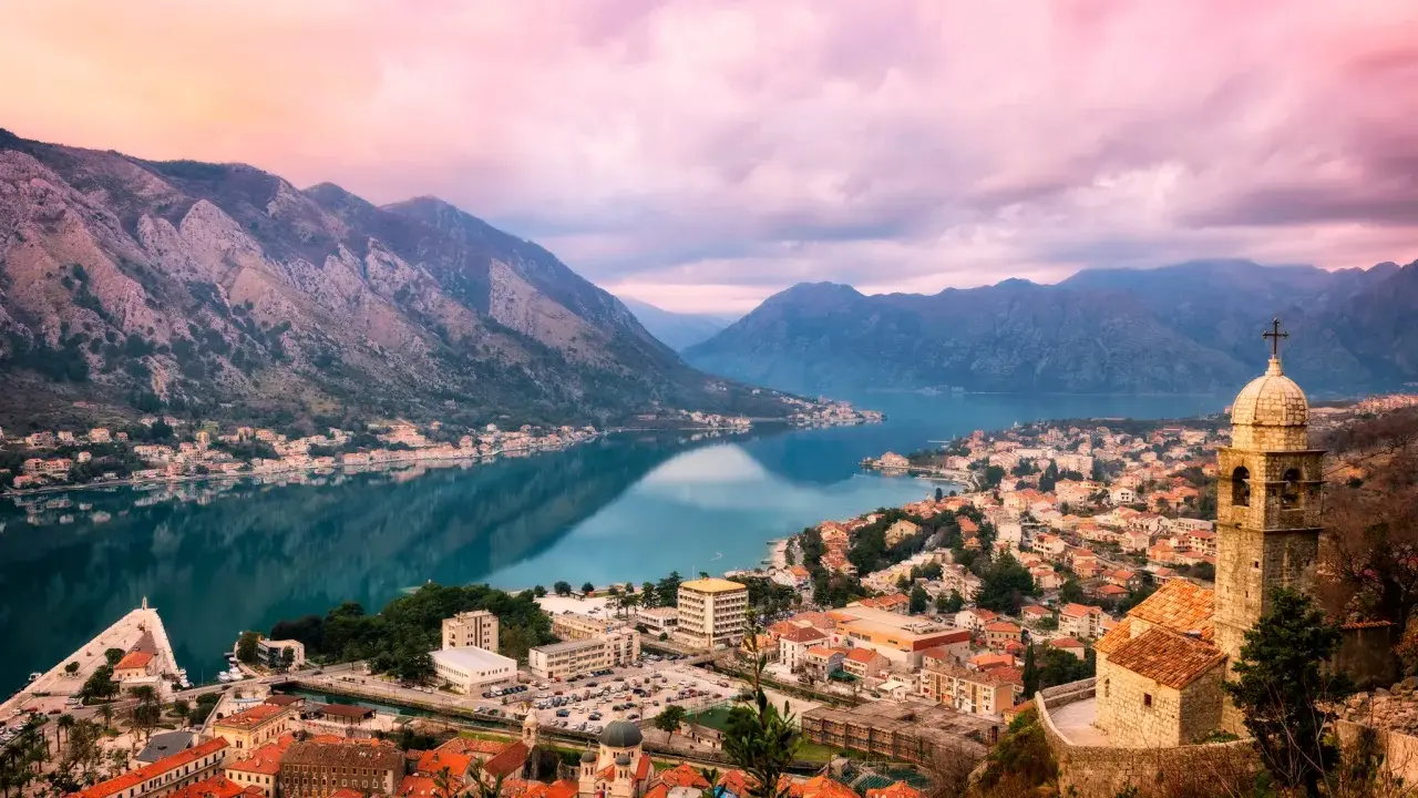 Vacker vy över Kotorbukten i Montenegro. En stad med röda tak och en kyrka vid vattnet, omgiven av berg. En perfekt plats för montenegro mat.