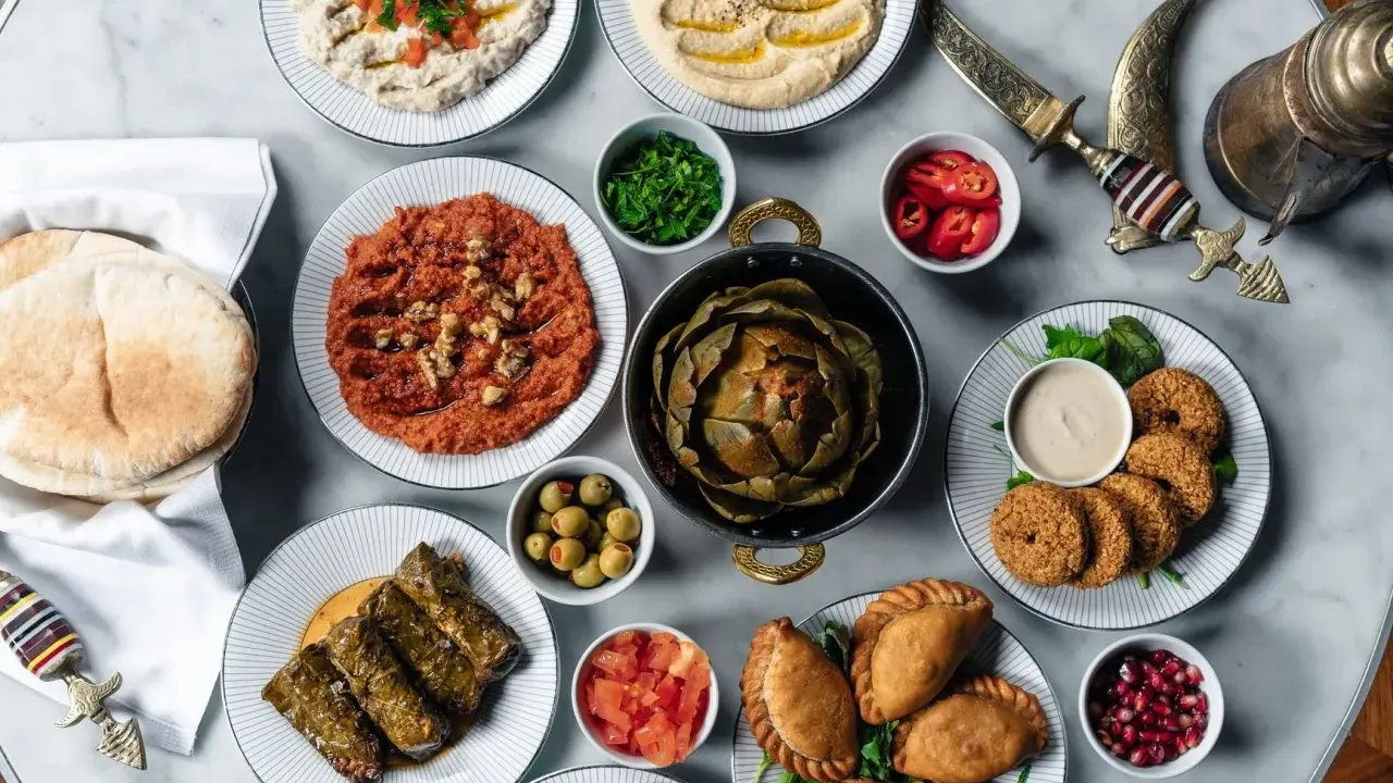 En generös dukning med libanesisk mat: hummus, baba ghanoush, falafel, dolmar, piroger och en hel kronärtskocka.