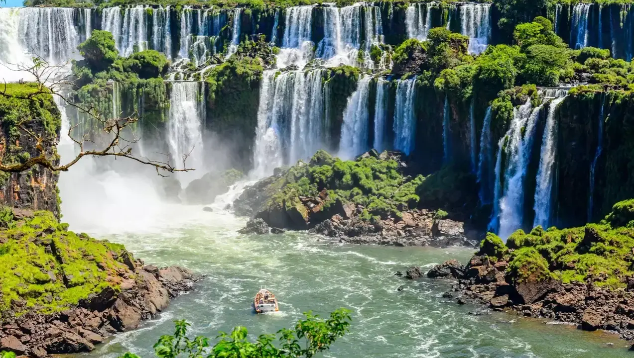 Imponerande vattenfall i Iguazú, Argentina. En båt närmar sig de brusande fallen, en del av fakta om Argentina.