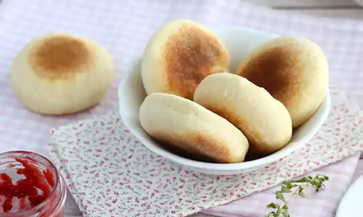 Mjukkaka i stekpanna, gyllene och fluffiga, serveras i en skål med en burk sylt bredvid. Perfekt för frukost eller fika.