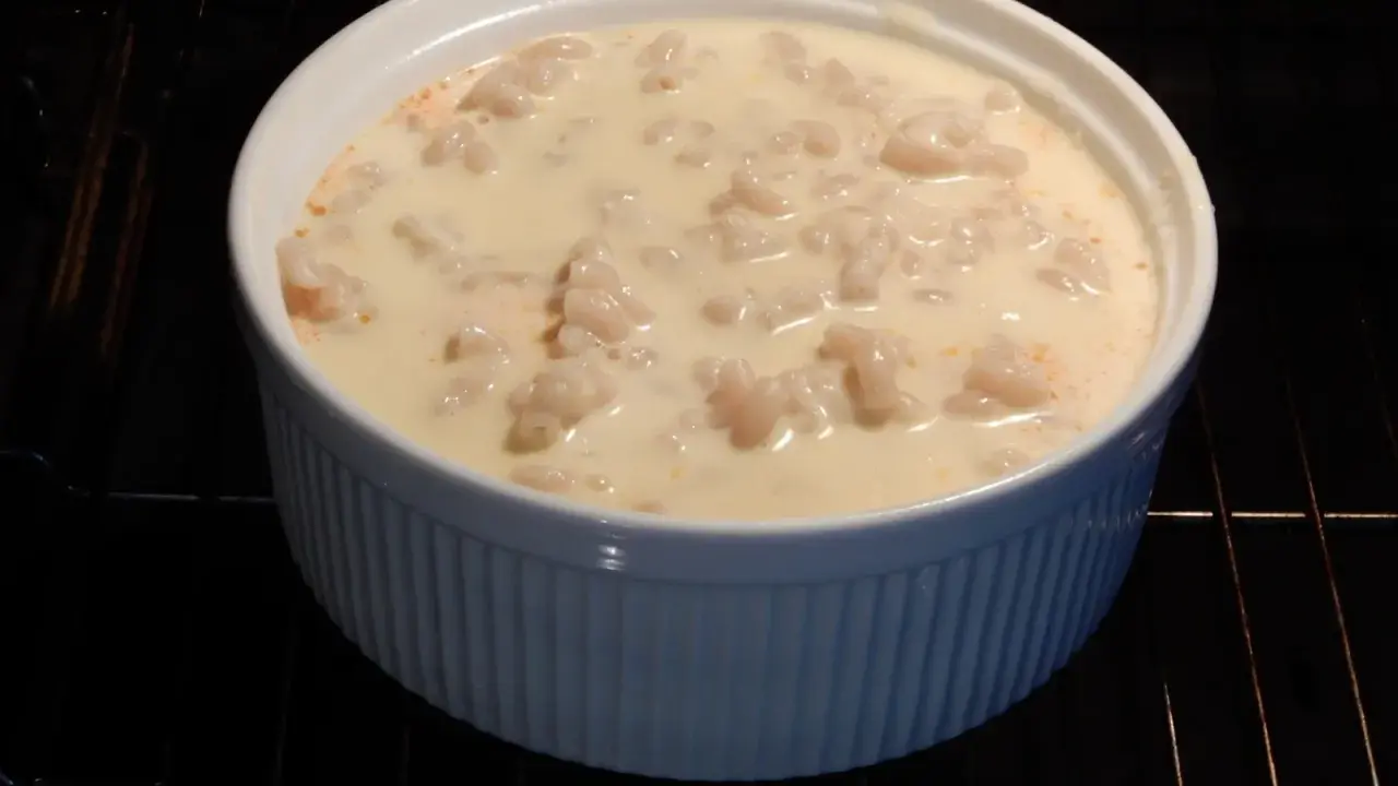 En vit ugnsform med makaroner i en krämig sås, redo för ett läckert pastitio recept.