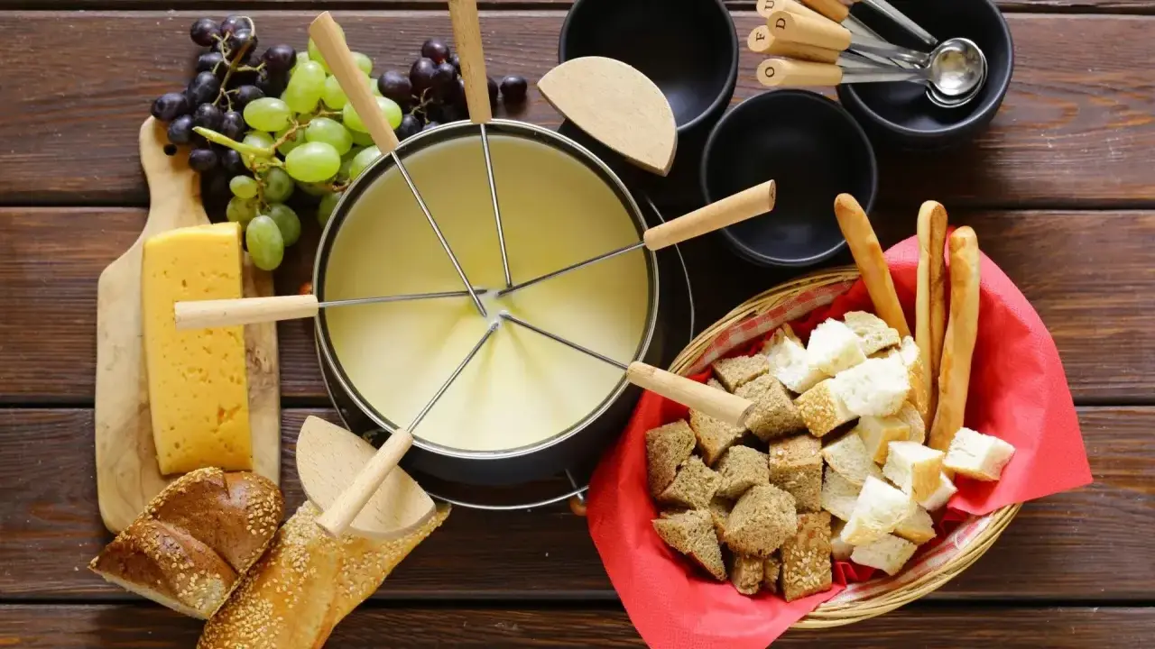 En härlig ostfondue, en klassisk schweizisk matupplevelse, med bröd, vindruvor och ost.