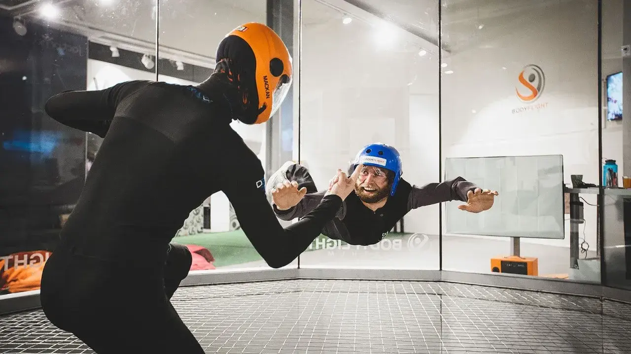 Två personer i flygtunnel, en instruktör och en person som flyger. En av de roliga aktiviteterna i Stockholm!