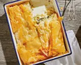 En gyllene, krispig spenatpaj i en blå kantad form. Perfekt för ett spanakopita recept.