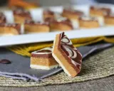 Två bitar av marockansk mat, en chokladkaka med lager av nougat och vit choklad, dekorerad med virvlar av vit och mörk choklad.