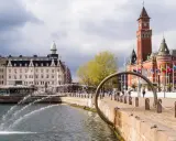 Vattenfontäner vid hamnen i Helsingborg, med Rådhuset i bakgrunden. Perfekt för en promenad bland sevärdheter.