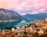 Vacker vy över Kotorbukten i Montenegro. En stad med röda tak och en kyrka vid vattnet, omgiven av berg. En perfekt plats för montenegro mat.