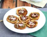 Små, rostade brödskivor toppade med grönt pesto, soltorkade tomater och riven ost. Perfekt som en enkel pesto toast.