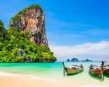 Klong Nin Beach med turkost vatten, vita stränder, grönskande klippor och traditionella longtailbåtar. En idyllisk thailändsk dröm.