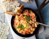 En smak av cypern mat: äggröra med tomat och örter i en gjutjärnspanna, serverad med ett gott bröd.