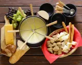 En härlig ostfondue, en klassisk schweizisk matupplevelse, med bröd, vindruvor och ost.