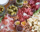 En härlig ost och charkbricka med salami, prosciutto, osttärningar, kapris, cornichoner, nötter och passionsfrukt.