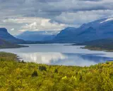 Vacker sjö omgiven av höstfärgad skog och berg. Perfekt för vandring dagsturer Sverige.