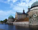 Imponerande slott med kupoler och vallgrav. En perfekt plats att besöka Vadstena för en historisk upplevelse.