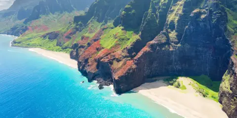 Fakta om Hawaii: Dramatiska gröna berg möter turkost hav och vita stränder längs Na Pali Coast på Kauai.