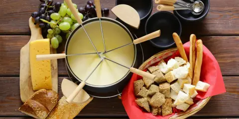 En härlig ostfondue, en klassisk schweizisk matupplevelse, med bröd, vindruvor och ost.