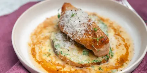 En elegant rätt med kött, grön puré och en krämig sås, toppad med riven ost och örter. Ett perfekt fine dining recept.