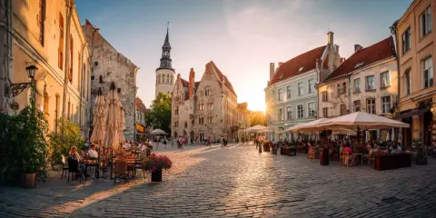 Solnedgång över kullerstensbelagd torg i Tallinn, med uteserveringar och historiska byggnader. Perfekt för **europa tips**.