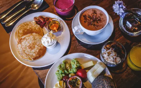 En härlig brunch med pannkakor, frukt, yoghurt och en kopp varm choklad. Perfekt för en lugn morgon.