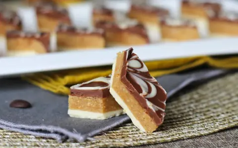Två bitar av marockansk mat, en chokladkaka med lager av nougat och vit choklad, dekorerad med virvlar av vit och mörk choklad.