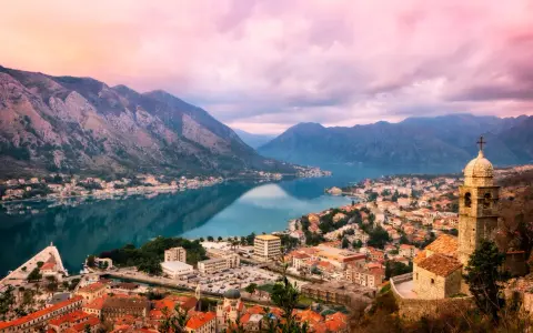 Vacker vy över Kotorbukten i Montenegro. En stad med röda tak och en kyrka vid vattnet, omgiven av berg. En perfekt plats för montenegro mat.