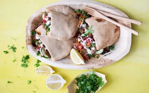 Läckra pitabröd fyllda med saftigt kött, grönsaker och en krämig sås. En härlig bit turkisk mat, serverad med citron och färska örter.