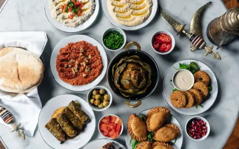 En generös dukning med libanesisk mat: hummus, baba ghanoush, falafel, dolmar, piroger och en hel kronärtskocka.