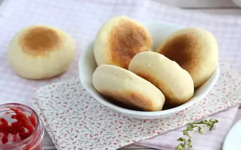 Mjukkaka i stekpanna, gyllene och fluffiga, serveras i en skål med en burk sylt bredvid. Perfekt för frukost eller fika.