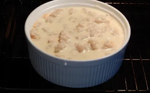 En vit ugnsform med makaroner i en krämig sås, redo för ett läckert pastitio recept.