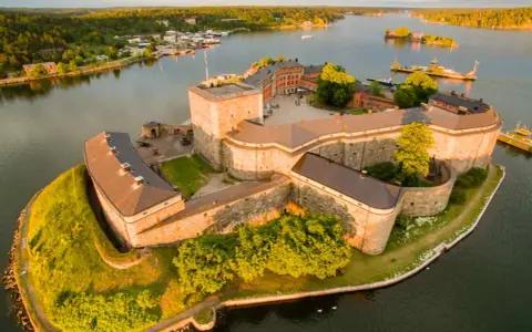 Vaxholms kastell, en av de fina platserna i Stockholm, badar i solljus vid vattnet.