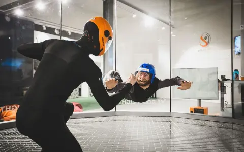 Två personer i flygtunnel, en instruktör och en person som flyger. En av de roliga aktiviteterna i Stockholm!