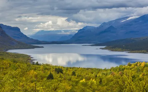 Vacker sjö omgiven av höstfärgad skog och berg. Perfekt för vandring dagsturer Sverige.