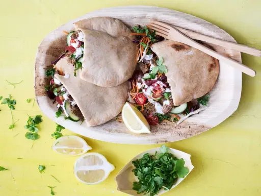 Läckra pitabröd fyllda med saftigt kött, grönsaker och en krämig sås. En härlig bit turkisk mat, serverad med citron och färska örter.