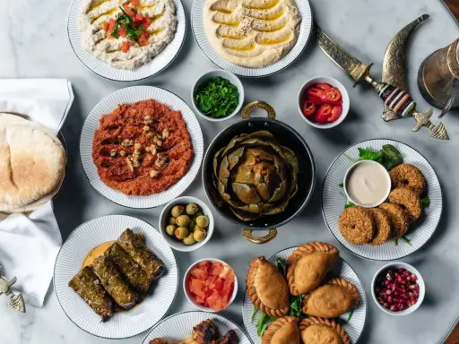 En generös dukning med libanesisk mat: hummus, baba ghanoush, falafel, dolmar, piroger och en hel kronärtskocka.