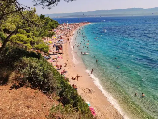 En solig dag på Zlatni Rat, en berömd strand med turkost vatten och många badande.