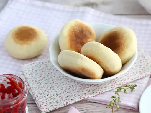 Mjukkaka i stekpanna, gyllene och fluffiga, serveras i en skål med en burk sylt bredvid. Perfekt för frukost eller fika.