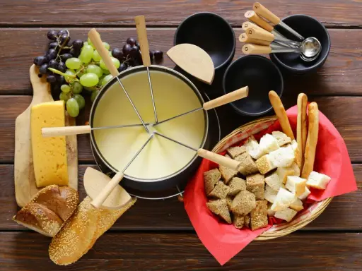 En härlig ostfondue, en klassisk schweizisk matupplevelse, med bröd, vindruvor och ost.