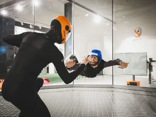Två personer i flygtunnel, en instruktör och en person som flyger. En av de roliga aktiviteterna i Stockholm!
