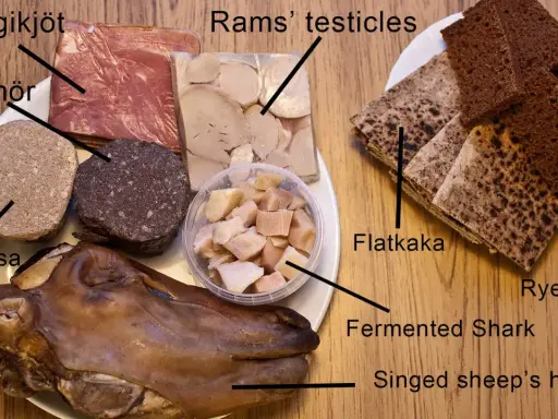 En tallrik med isländsk mat: hangikjöt, blóðmör, lifrarpylsa, rams' testiklar, fermenterad haj, singed sheep's head, flatkaka och rågbröd.