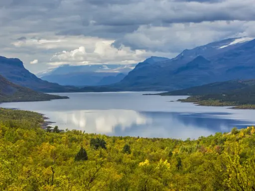 Vacker sjö omgiven av höstfärgad skog och berg. Perfekt för vandring dagsturer Sverige.