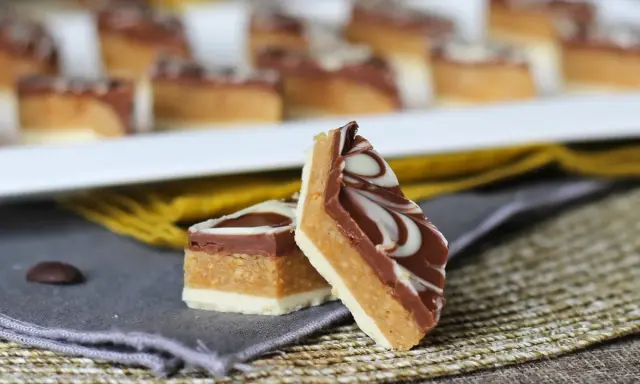 Två bitar av marockansk mat, en chokladkaka med lager av nougat och vit choklad, dekorerad med virvlar av vit och mörk choklad.