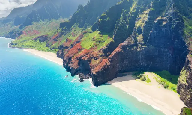 Fakta om Hawaii: Dramatiska gröna berg möter turkost hav och vita stränder längs Na Pali Coast på Kauai.