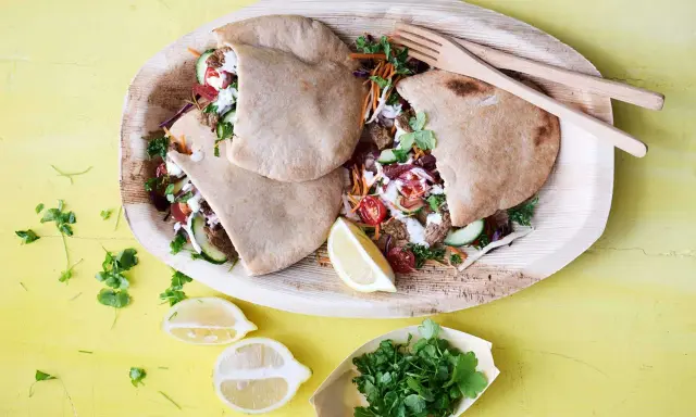 Läckra pitabröd fyllda med saftigt kött, grönsaker och en krämig sås. En härlig bit turkisk mat, serverad med citron och färska örter.