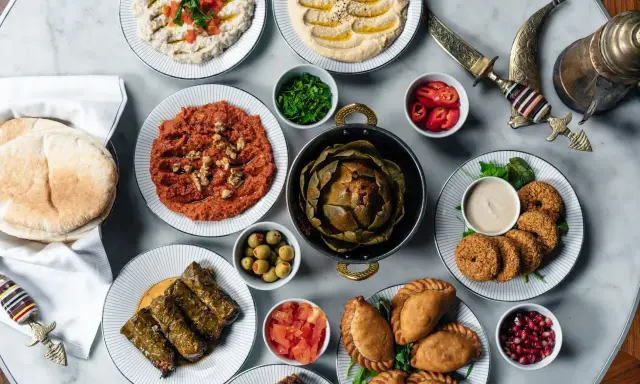 En generös dukning med libanesisk mat: hummus, baba ghanoush, falafel, dolmar, piroger och en hel kronärtskocka.