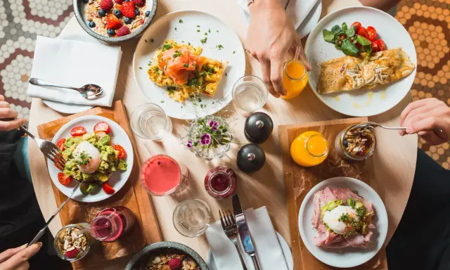 En härlig frukost i Stockholm med ägg, lax, avokadotoast, granola och juice.