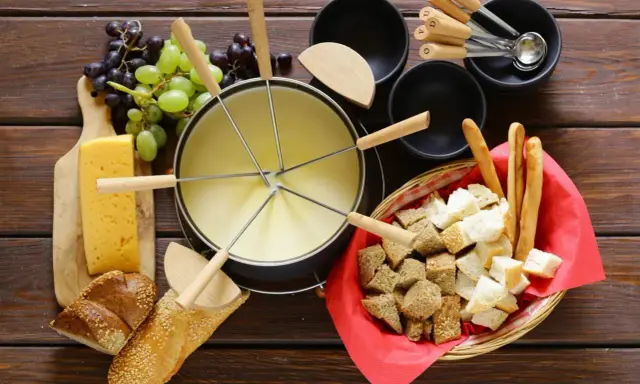 En härlig ostfondue, en klassisk schweizisk matupplevelse, med bröd, vindruvor och ost.