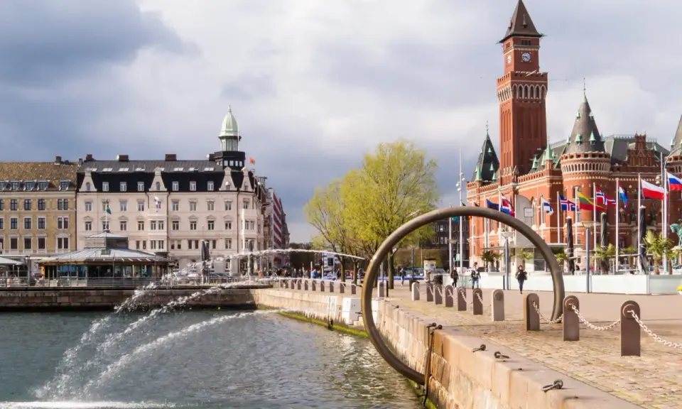 Vattenfontäner vid hamnen i Helsingborg, med Rådhuset i bakgrunden. Perfekt för en promenad bland sevärdheter.