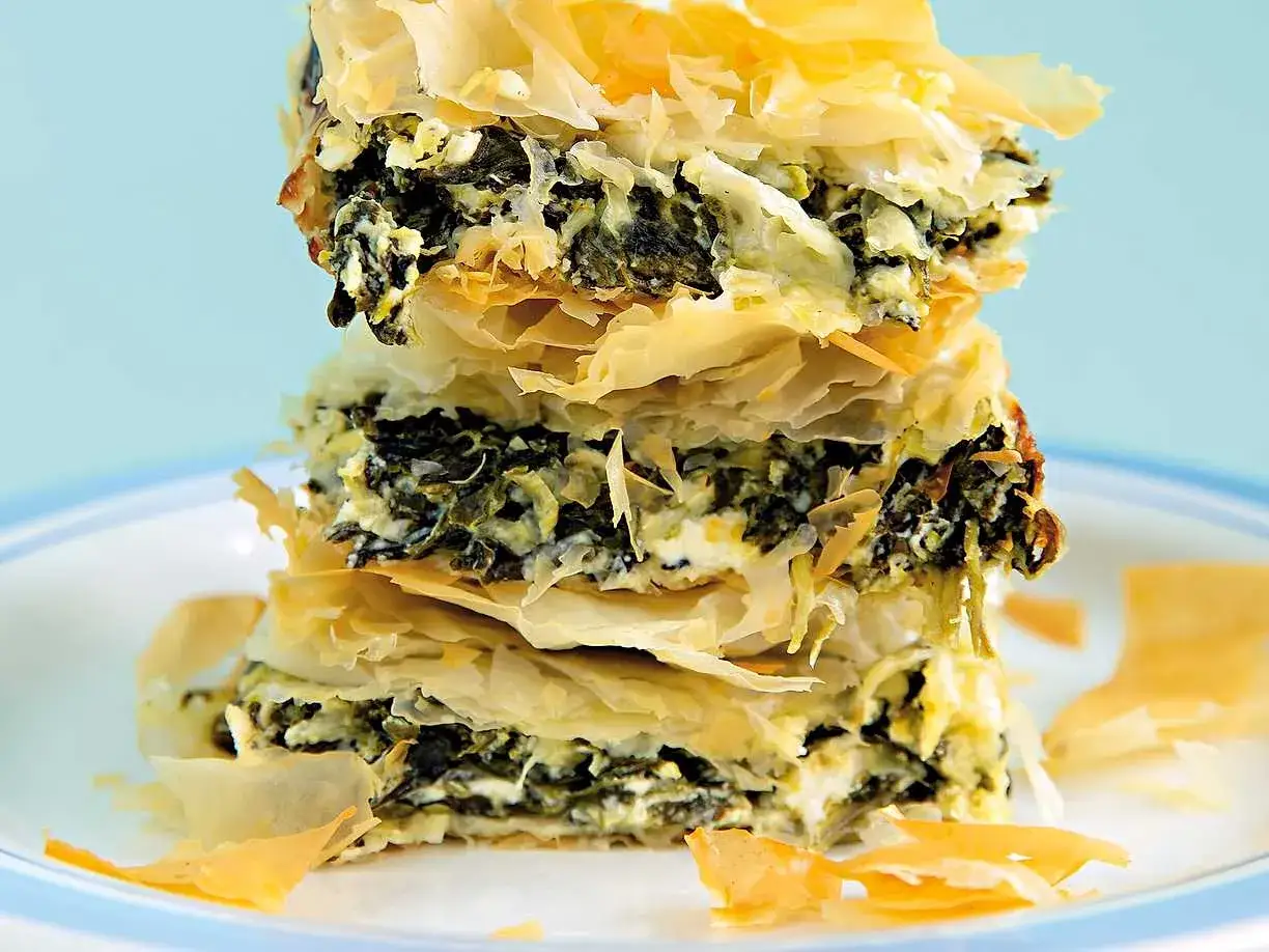 En stapel krispiga filodegslager fyllda med spenat och ost. Ett läckert spanakopita recept som ser fantastiskt ut!