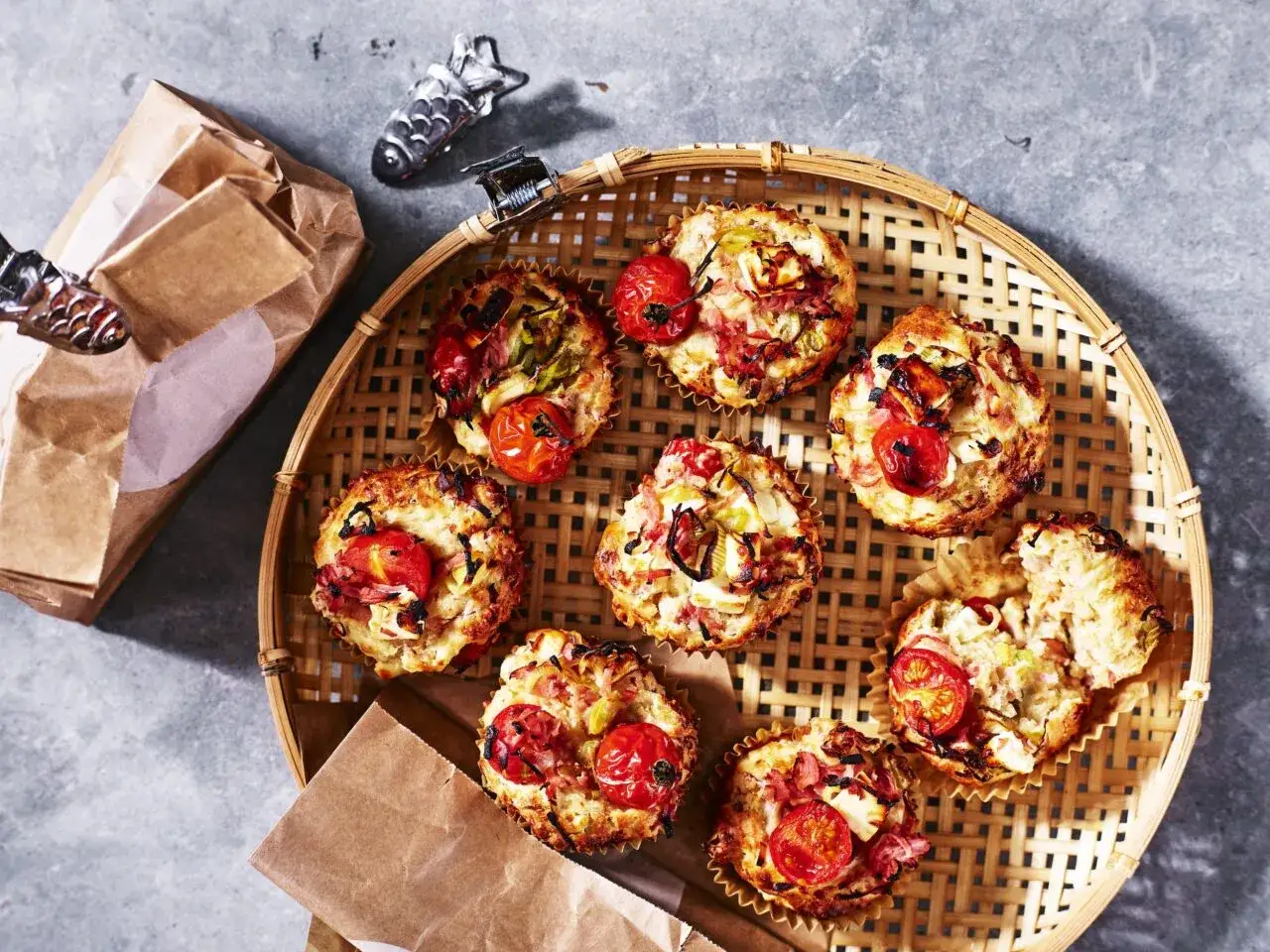Matiga muffins med havregryn, tomat och bacon på en flätad bricka. Perfekt för en snabb och mättande frukost eller mellanmål.
